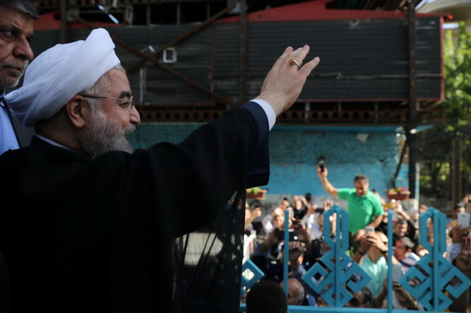 Ứng viên đương kim tổng thống Hassan Rouhani vẫy chào người ủng hộ sau khi ông bỏ phiếu ở thủ đô Tehran ngày 19-5 - Ảnh: Reuters