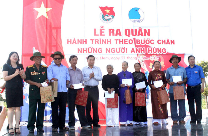 Anh Nguyễn Phi Long (ngoài cùng bìa phải) trao quà cho gia đình có công cách mạng và thương, bệnh binh - Ảnh: THANH BA