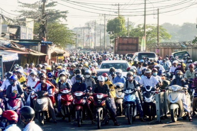 Xe hơi và xe máy chen nhau trên một con đường ở Campuchia - Ảnh: Getty Images