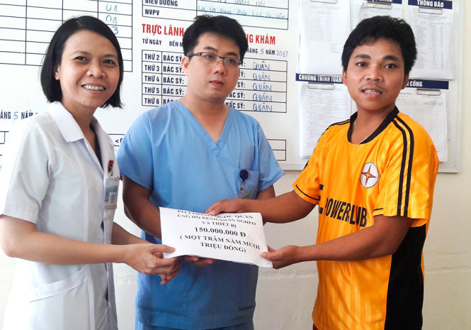 Bác sĩ Trần Thị Hoàng (phải), phó giám đốc Bệnh viện Phụ sản – nhi Đà Nẵng, tiếp nhận khoản hỗ trợ từ anh Pơloong Thơi (trái) - Ảnh: TẤN LỰC