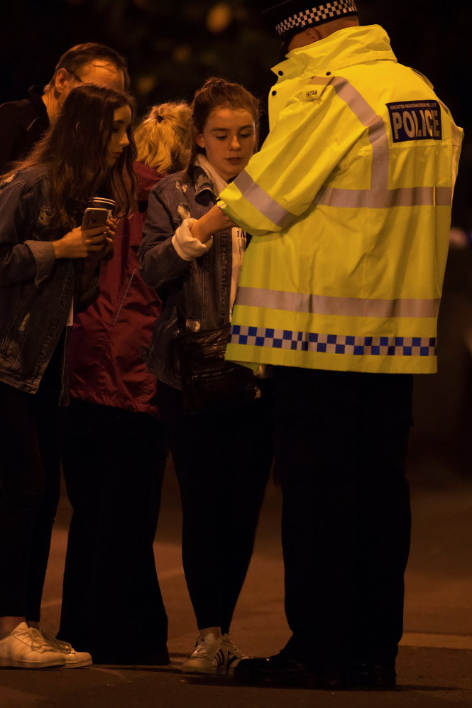 Cảnh sát Anh hỗ trợ các nạn nhân chạy thoát được khỏi khu vực nguy hiểm - Ảnh: Reuters