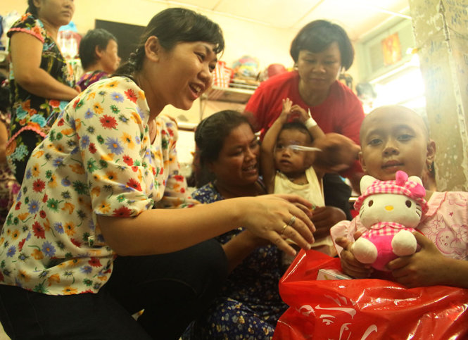 Chị Nguyễn Thị Hương- Ủy viên Ban biên tập báo Tuổi Trẻ tặng quà, thăm hỏi bệnh nhi tại phòng bệnh - Ảnh: D.NGUYỄN