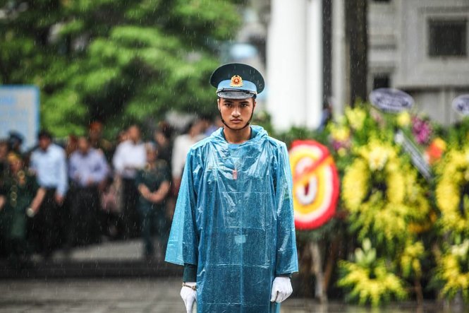 Tác phẩm Một chiến sĩ đứng gác dưới mưa trong lễ tang đội bay CASA 212 tại Nhà tang lễ bộ Quốc phòng ngày 30-6-2016 của tác giả Nam Trần