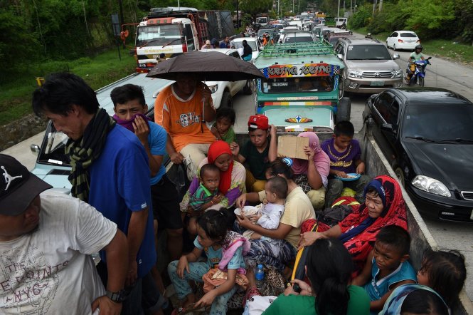 Người dân địa phương mang theo bất cứ những gì có thể rút chạy tới nơi an toàn. Người chạy bộ, người đi xe. Giao thông tê liệt trên các tuyến đường chính ra, vào tại Marawi - Ảnh: AFP