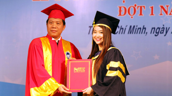 PGS.TS Phạm Hữu Hồng Thái trao bằng tốt nghiệp thạc sĩ cho các học viên chương trình liên kết giữa Trường ĐH Tài chính = marketing với Trường ĐH HELP (Malaysia) sáng 27-5 - Ảnh: TRẦN HUỲNH
