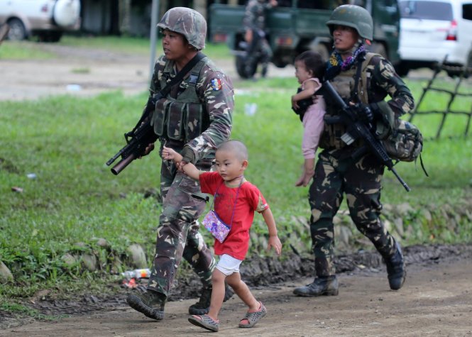 Binh sĩ Philippines đưa các em nhỏ theo tới nơi trú ẩn - Ảnh: EPA