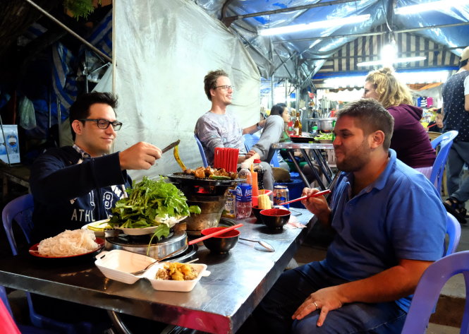 Du khách nước ngoài ăn uống tại chợ đêm Đà Lạt - Ảnh: M.Vinh