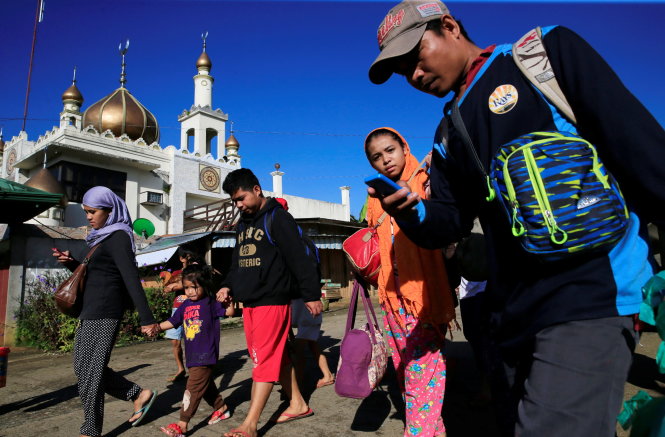 Người dân ở Marawi đi ngang qua đền thờ Hồi giáo trong đợt di tản ngày 26-5 - Ảnh: Reuters