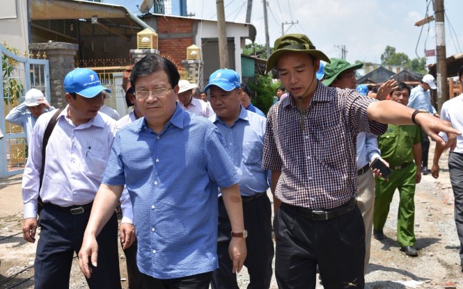 ông Thi (phải) đi cùng PTT Trịnh Đình Dũng trong chuyến khảo sát sạt lở tại xã Mỹ Hội Đông vừa qua - Ảnh: Bửu Đấu