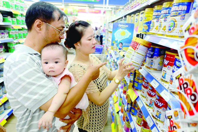 Vợ chồng anh Minh, chị Thảo tìm mua sữa hộp cho con 6 tháng tuổi tại siêu thị Co.op Mart, TP.HCM - Ảnh: Quang Định