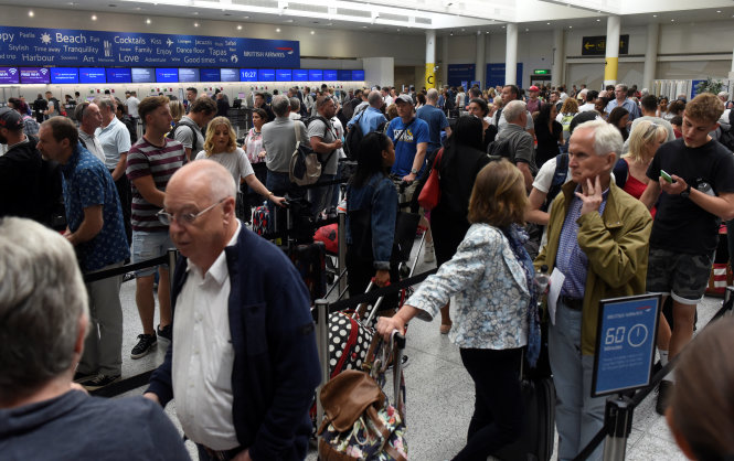 Hành khách xếp hàng dài đợi làm thủ tục tại quầy của British Airways ở sân bay Gatwick một ngày sau sự cố máy tính ngày 27-5 - Ảnh: Retuers