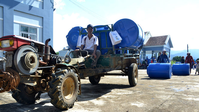 Người dân thôn 3A xã Sông Hinh dùng xe công nông chở bồn nước về nhà - Ảnh: DUY THANH