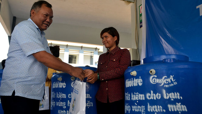 Ông Ksor Y Phun - phó chủ tịch UBND huyện Sông Hinh - trao quà và bồn nước cho dân xã Sông Hinh - Ảnh: DUY THANH