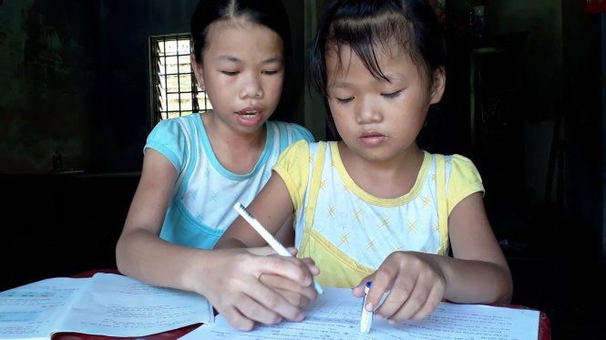 Dù đã nghỉ học nhưng Nguyễn Thị Tuyết Mai (trái) vẫn thường cùng em gái ôn bài - Ảnh : NHẬT LINH