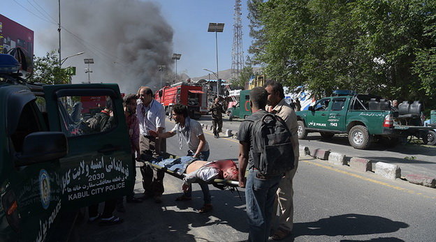 Mọi người giúp đưa nạn nhân đi bệnh viện - Ảnh: AFP