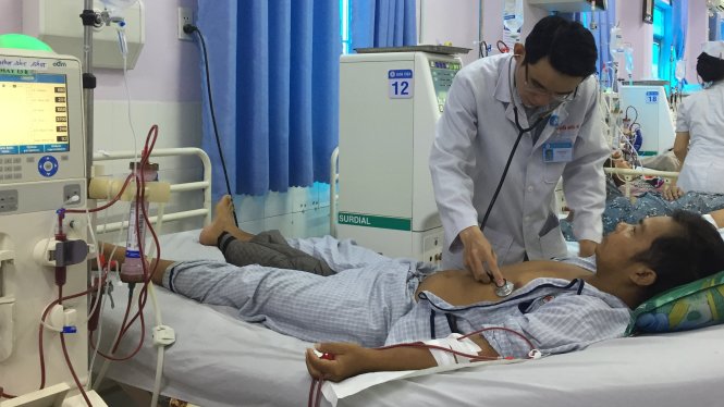 Bác sĩ Nguyễn Quốc Vũ đang thăm khám cho bệnh nhân đang chạy thận - Ảnh: Lam Xuân