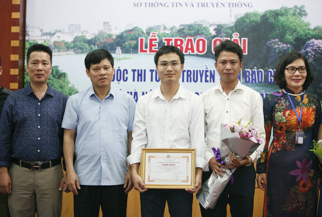 Phóng viên Vũ Viết Tuân báo Tuổi trẻ (đứng giữa) nhận giải ba của cuộc thi- Ảnh: NAM TRẦN