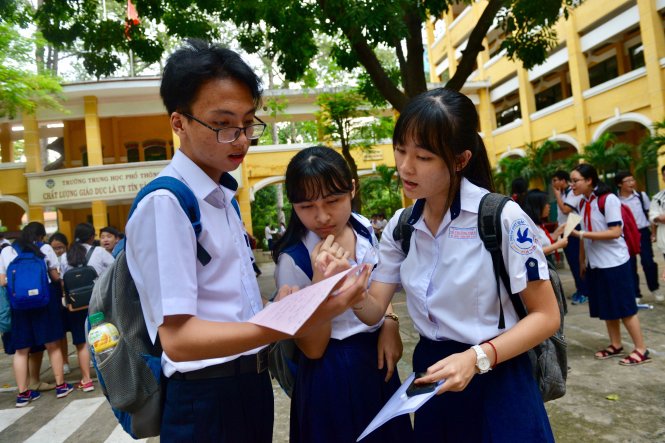 Các em học sinh trao đổi đáp án sau khi kết thúc môn Ngoại ngữ tại hội đồng thi Trường THPT Trưng Vương (Q.1) - Ảnh: Duyên Phan