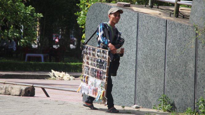 Một người bán kính dạo ở TP Vinh mệt mỏi bán hàng trong nắng nóng - Ảnh: Doãn Hòa