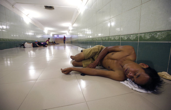 Một người đàn ông cởi trần nằm ngủ dưới hầm đi bộ trên đường Nguyễn Xiển, Thanh Trì - Ảnh: NAM TRẦN