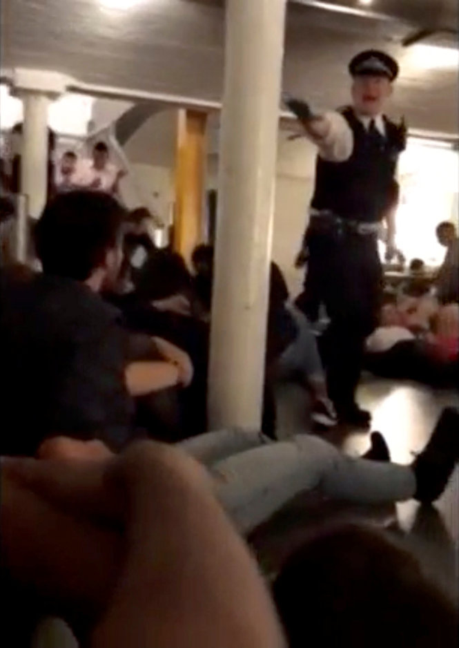 Cảnh sát yêu cầu mọi người di tản bên trong một quán bar ở London - Ảnh: Reuters