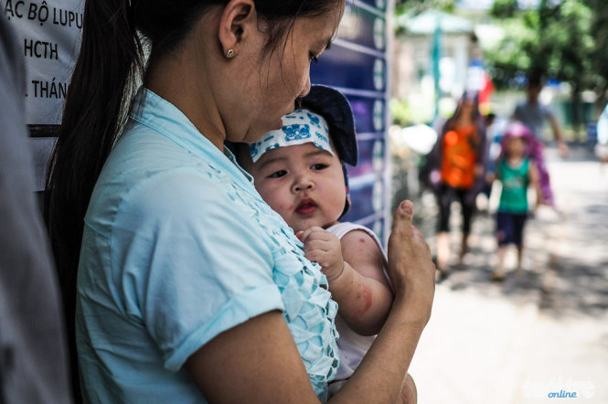Bé Vy 6 tháng tuổi quê tại Hoà Bình bị viêm phổi đang cùng với gia đình chờ xe để trở về quê - Ảnh: Nguyễn Khánh