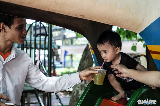 Một bé trai đang được bố cho uống nước - Ảnh: Nguyễn Khánh