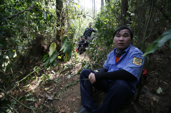 Lượng cảnh sát chưa cháy rừng và bảo vệ rừng ngồi nghỉ sau khi cơ bản dập tắt nhưng đốm cháy bùng lại- Ảnh: NAM TRẦN