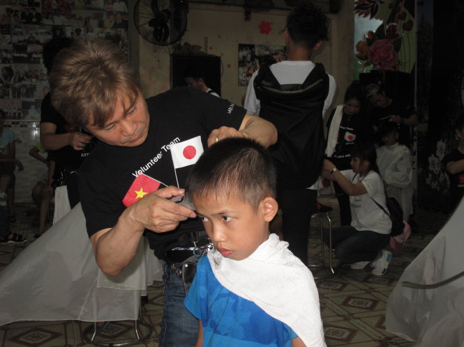 Ông Nakahashi hớt tóc cho trẻ em tại Trung tâm nhân đạo ở Bình Dương vào chiều 5-6 - Ảnh: C.Nhật