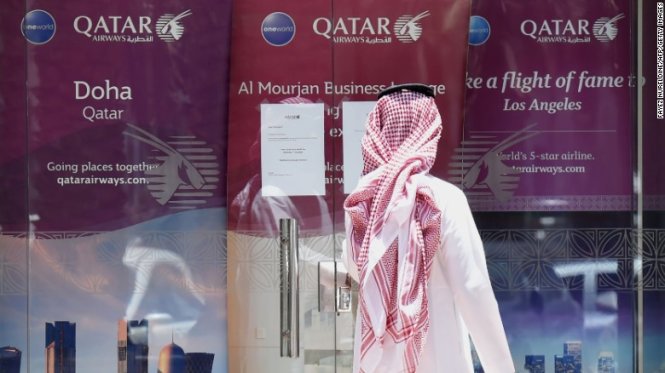 Một người đàn ông đứng bên ngoài một đại lý của Qatar Airways - Ảnh: AFP