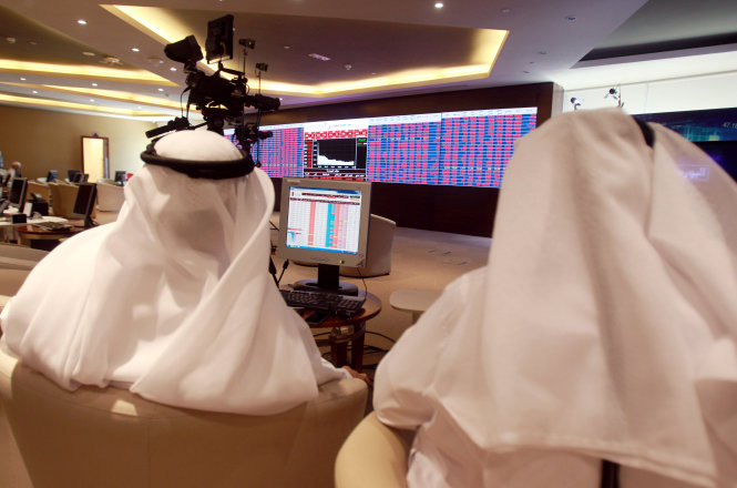 Các nhà đầu tư theo dõi thông tin thị trường chứng khoán tại sàn giao dịch chứng khoán Qatar ở thủ đô Doha - Ảnh: Reuters