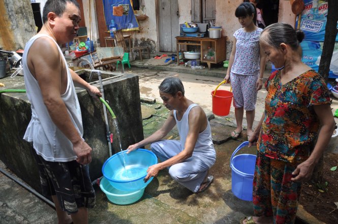 Một khu dân cư ở quận Thanh Xuân (Hà Nội) phải đi xin nước sinh hoạt sau khi bị cắt nước nhiều ngày - Ảnh: Quang Thế