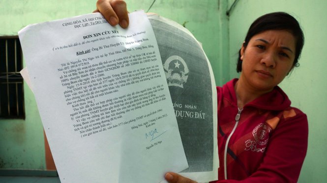 Bà Nguyễn Thị Nga với xấp đơn khiếu nại, khiếu kiện gần 10 năm nay - Ảnh: Đức Trong