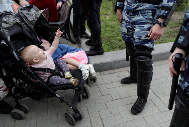 Có người đưa cả con nhỏ tham gia cuộc biểu tình trưa 12-6 ở thủ đô Matxcơva - Ảnh: Reuters