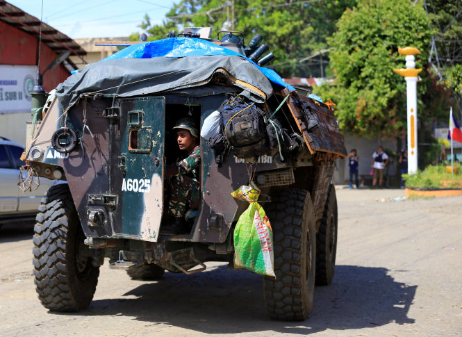 Binh sĩ Philippines ngồi sau một xe bọc thép được gia cố sơ sài bằng gỗ và ống thép trên đường phố Marawi - Ảnh: Reuters