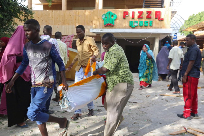 Đưa thi thể nạn nhân khỏi nhà hàng Pizza House vào sáng 15-6 - Ảnh: Reuters