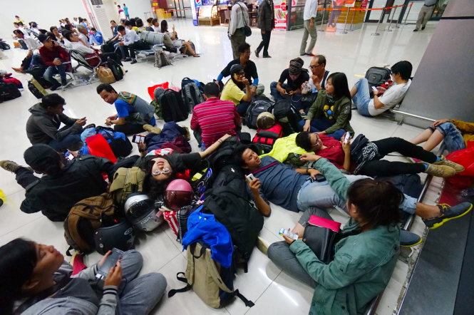 Hành khách đang đối diện tỉ lệ chậm chuyến bay tăng. Trong ảnh: hành khách nằm vật vạ chờ chuyến bay do bị hoãn tại sân bay Nội Bài - Ảnh: Q.ĐỊNH