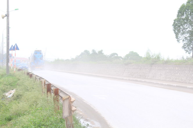 Đường đê Nguyễn Khoái đoạn gần đường vào cảng Khuyến Lương vẫn bụi mù mịt dù hàng ngày được tưới nước 3-4 lần. ảnh chụp sáng 17-6. ảnh : Chí Tuệ