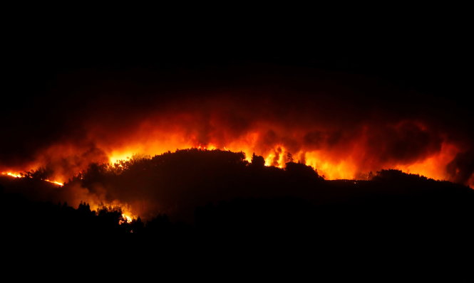 Cảnh lửa đỏ rực trong đêm 17-6 ở Tojeira, miền trung Bồ Đào Nha - Ảnh: Reuters