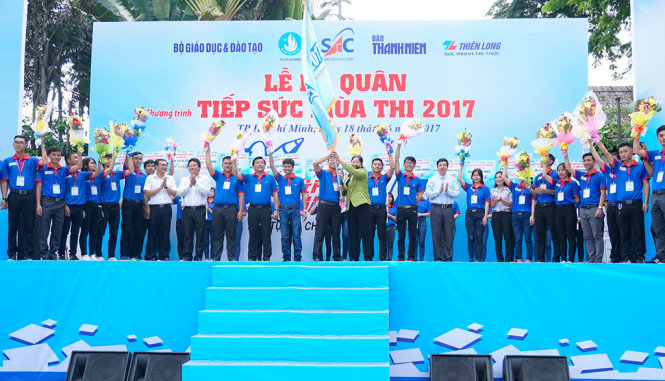 Bà Nguyễn Thị Bích Ngọc - phó trưởng Ban dân vận Thành ủy TP.HCM – trao hoa và cờ cho ban tổ chức, đội trưởng các đội tiếp sức mùa thi tại chương trình - Ảnh: NAM TRẦN