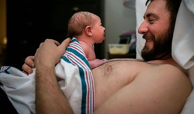 “This baby’s mom had just handed her to her father for some skin-to-skin ... and this sweet girl was clearly absolutely smitten! At less than two hours old, she was raising her head to look straight into his eyes.” - Ảnh: Capturing Joy Birth Services