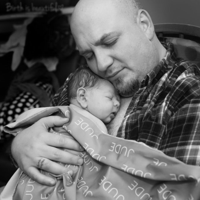 “This dad’s pregnant wife and unborn daughter tragically passed away years ago. He has their names tattooed on his ring finger, which is visible in the photo. Later, he met and fell in love with his wife. This is their first son, Jude. Holding him for the first time skin-to-skin was a very emotional moment.” - Ina