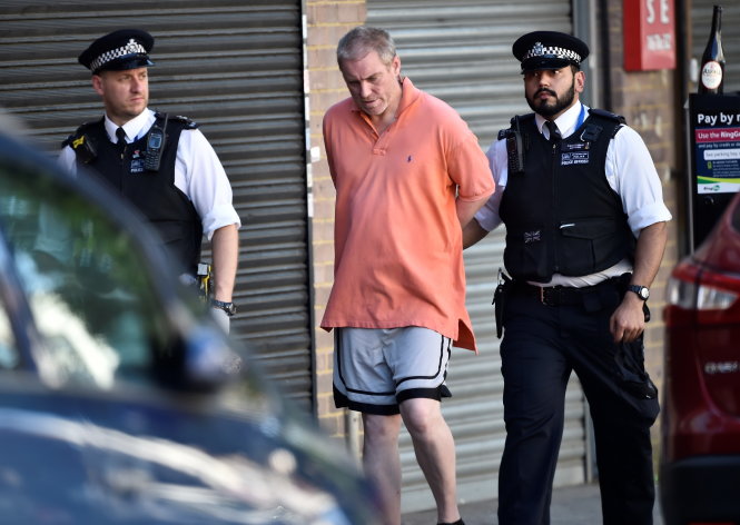 Cảnh sát Anh bắt giữ một người đàn ông da trắng - Ảnh: Reuters