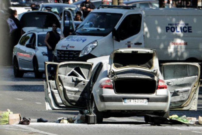 Chiếc xe mở tung cửa và cốp xe trên đại lộ Champs-Elysees ngày 19-6 sau khi đâm vào xe cảnh sát - Ảnh: AFP
