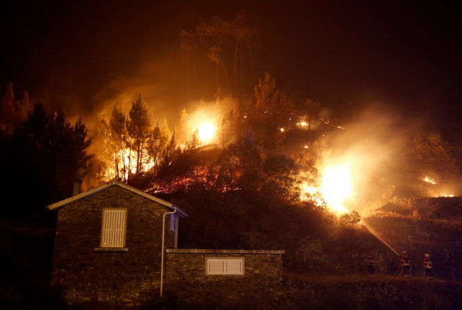 Lửa cháy rừng đe dọa căn nhà ở Carvalho tối 19-6 - Ảnh: Reuters