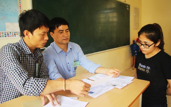 Giám thị đối chiếu hồ sơ thí sinh tại điểm thi Trường THPT chuyên Phan Bội Châu, TP Vinh chiều 21-6 - Ảnh: Doãn Hòa