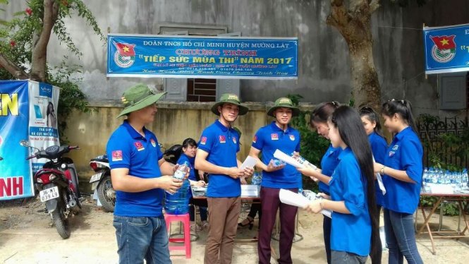 Các bạn tình nguyện viên của Huyện đoàn Mường Lát (Thanh Hóa) tặng nước uống cho thí sinh đến dự thi tại điểm thi Trường THPT Mường Lát - Ảnh: Hà Đồng