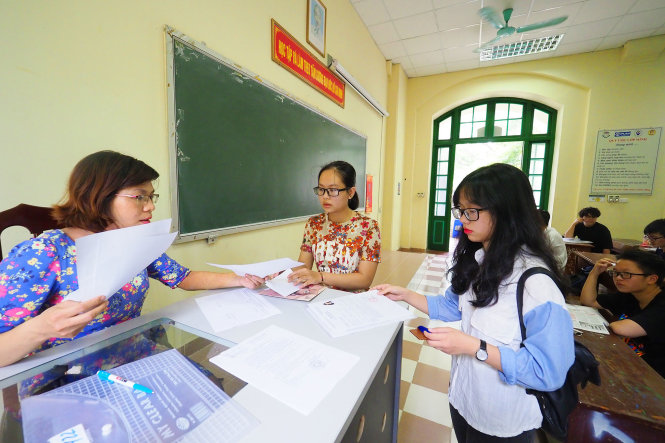 Một giám thị đang đối chiếu hồ sơ thi của các thí sinh - Ảnh: Nguyễn Khánh