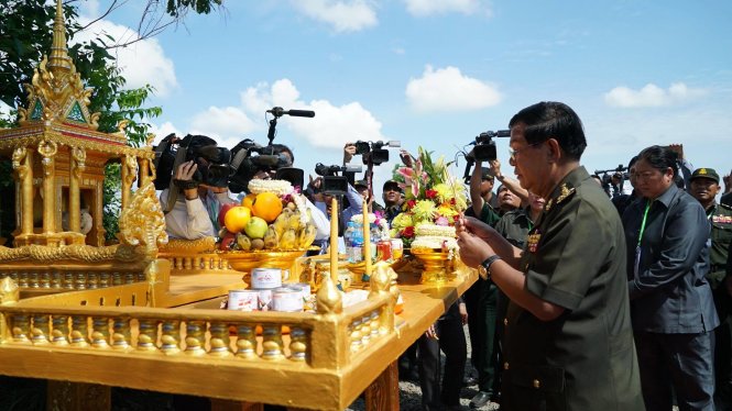Thủ tướng Hun Sen thắp nhang trước bàn thờ dưới gốc cây thị bần - Ảnh: THUẬN THẮNG