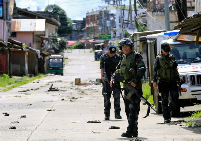 Cảnh sát Philippines canh gác trên tuyến đường chính ở thành phố Marawi ngày 22-6 - Ảnh: Reuters